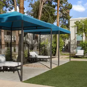 A cozy seating and lounging area at Sono Tempe Apartments beside the swimming pool under a square tent.