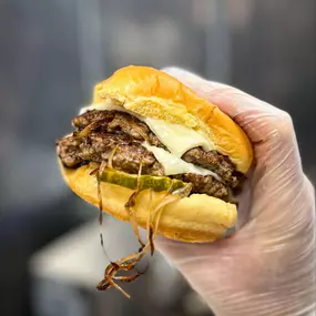 Grass fed house made beef patties with caramelized onion, house burger sauce, crinkle cut pickles, melted American cheese