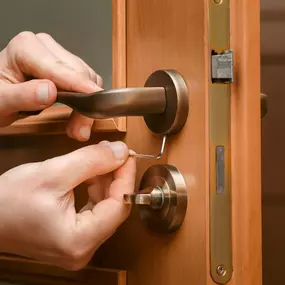 Locksmith repairing broken door lock.