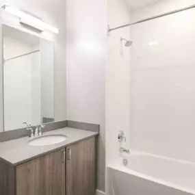 The bathroom at The One Atlantic Apartments features a relaxing bathtub for ultimate comfort.