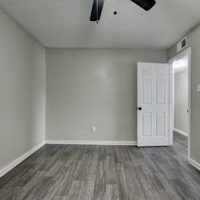 an empty living room with wood flooring and a white door