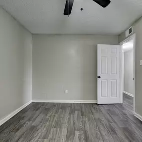 an empty living room with wood flooring and a white door