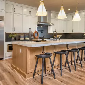 Kitchen in Luminary floor plan includes island with seating and sink at Daylight new construction homes in Las Vegas, NV