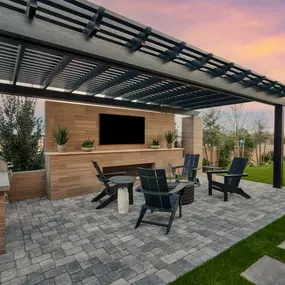 Backyard seating area in Luminary floor plan has grill and fireplace at Daylight new construction homes in Las Vegas, NV