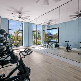 a workout room with mirrors and weights on a wooden floor