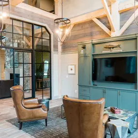 a living room with chairs and a tv