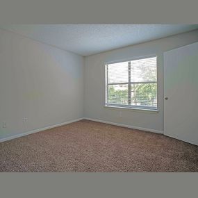 carpeted bedroom with large window in bedroom