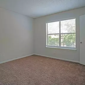 carpeted bedroom with large window in bedroom