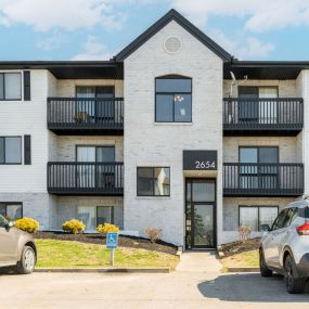 Exterior view of the Verandas North three-story apartment building with balconies and patios near resident parking.