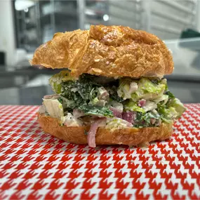 A delicious Chicken Caesar Croissant with homemade Caesar dressing on a flaky and delicious croissant and lemon zest.