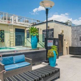 Outdoor view of the pool area of a building featuring the spa and lounge chairs