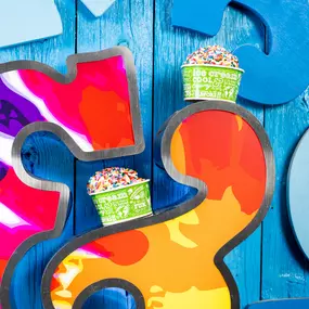 Two cups of ice cream with sprinkles on Ben & Jerry's Logo.