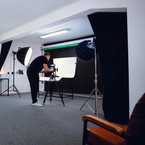 Fotograf bei der Arbeit im Studio von Welf Online, bei der Aufnahme eines neuen Fotoprojekts mit modernem Equipment.