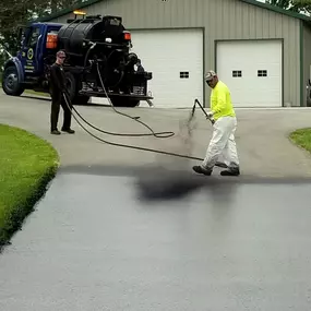 asphalt seal & repair employees sealcoating a driveway