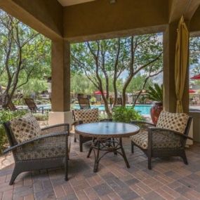 a patio with a table and chairs and a pool at Canyon Crossroads