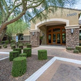 a building with a courtyard and trees in front of it at Canyon Crossroads