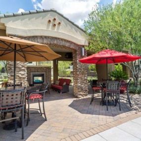 a patio with tables and umbrellas and a fireplace at Canyon Crossroads