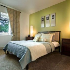 a bedroom with a bed and a lamp and a window at Canyon Crossroads