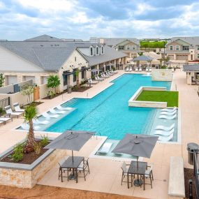 an aerial view of a swimming pool with chairs and umbrellas