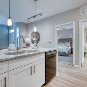 a kitchen with a sink and a door to a bedroom