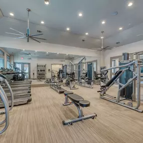 the gym in the clubhouse is equipped with cardio equipment and weights