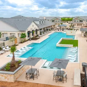 an aerial view of a swimming pool with chairs and umbrellas