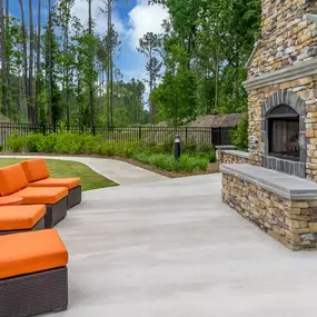 a concrete patio with orange couches and a stone fireplace at Sterling Creek