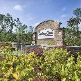 a sign on a brick building with trees in the background at Sterling Creek