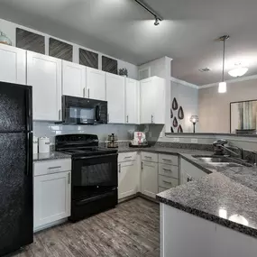 a kitchen with granite counter tops and black appliances at Sterling Creek