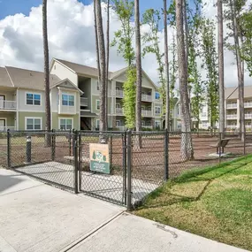 a fenced in dog park in front of an apartment building at Sterling Creek