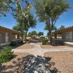 a courtyard between two buildings with trees and a pathway at Desert Sage