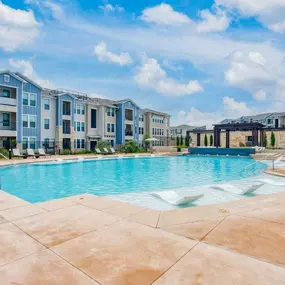 a large swimming pool with an apartment building in the background
