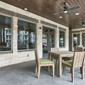 a covered patio with a wooden table and chairs at Legacy Flats