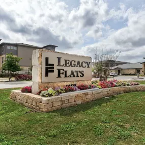 the sign for legacy flats in front of a building at Legacy Flats