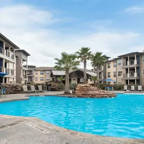 a large swimming pool with an apartment building in the background at Legacy Flats