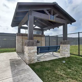 a picnic area with a bench in front of a fence at Legacy Flats