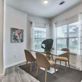 a dining room with a glass table and chairs at Legacy Flats