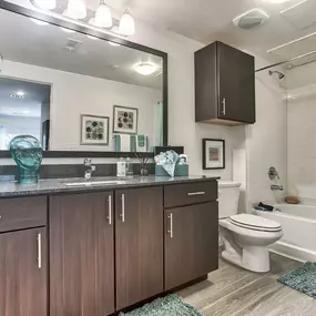 a bathroom with wooden cabinets and a toilet and a sink at Legacy Flats