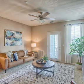 a living room with a couch and a ceiling fan at Spring Creek Apartments