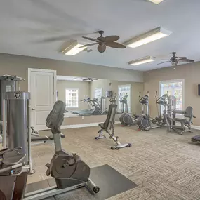 a gym with weights and a ceiling fan at Spring Creek Apartments