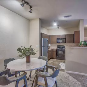 a dining room and kitchen with a table and chairs at Spring Creek Apartments