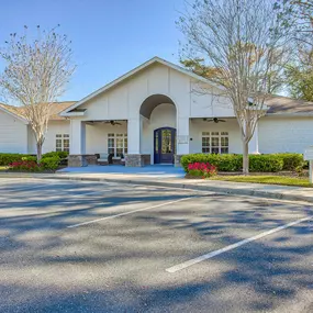 the front of a white building with a parking lot at Spring Creek Apartments