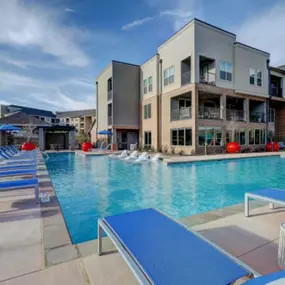 a swimming pool with blue tables and chairs at The Jane at Preston Trail