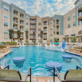 a swimming pool with an apartment building in the background