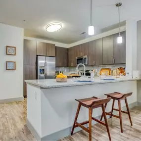 a kitchen with a counter top and some chairs