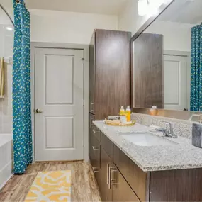 a bathroom with a shower and a sink and a mirror