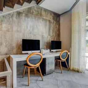 a home office with two computers on a desk with two chairs