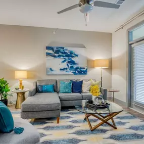 a living room with a couch and a ceiling fan