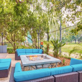 a lounge area with blue couches and a fire pit