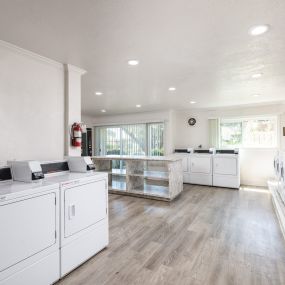 a washer and dryer room in a laundry room with white washes